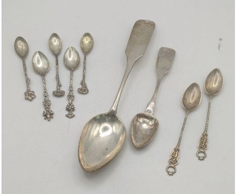 A group of silver and white metal spoons to include a white metal serving spoon along with the 800 silver tea spoons and othe