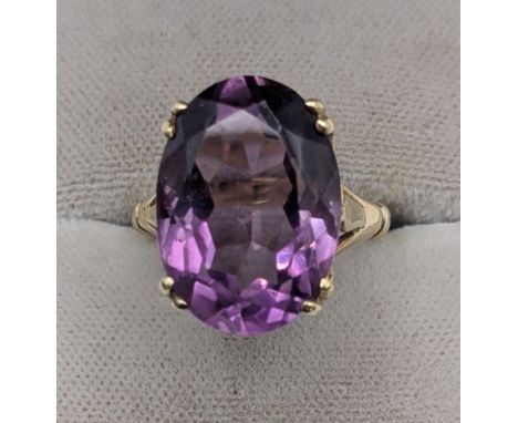 An oval cut amethyst in a four claw setting mounted in a 9ct yellow gold ring, measurements of amethyst 17.8mm x 12.6mm, tota