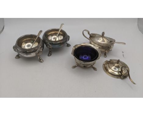 Silver condiment pots to include a pair of salts  on three feet along with one other, a mustard pot, a broken condiment lid a