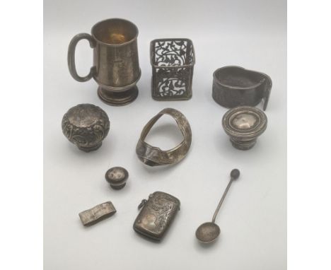 A group of silver items to include a Christening mug, a bangle A/F, a floral engraved vesta, silver bottle tops along with ot