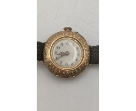 A late 19th century 14ct yellow gold floral engraved cased ladies wrist watch on a woven black fabric strap, total weight exc