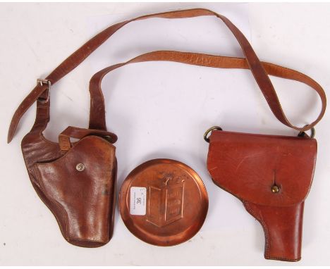 A collection of 20th century advertising/ militaria items to include; 2x leather gun holsters along with a copper ' Pratts Pe