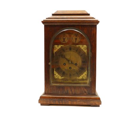 An oak mantel clock,19th century, the a gilt metal dial with Roman numerals, flanked by four putti heads, with Westminster an