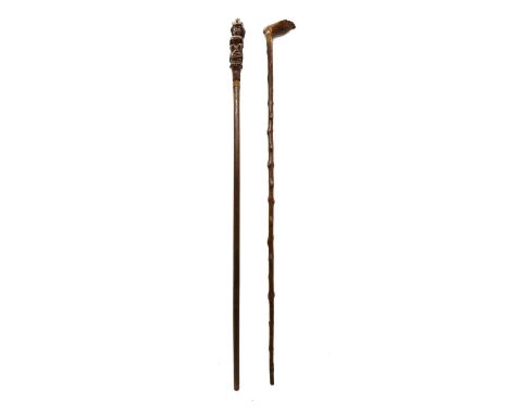 An 18th century wooden walking stick, the handle carved as a woman wearing a large bustle,86cm hightogether with another simi