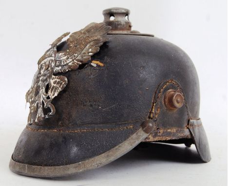 An antique WWI era Imperial German Pickelhaube helmet of leather construction. Complete with emblem to the front in brass and