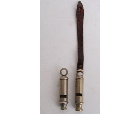 An original WWI dated 1917 First World War trench whistle, along with a WWII era ARP whistle. One with original leather strap