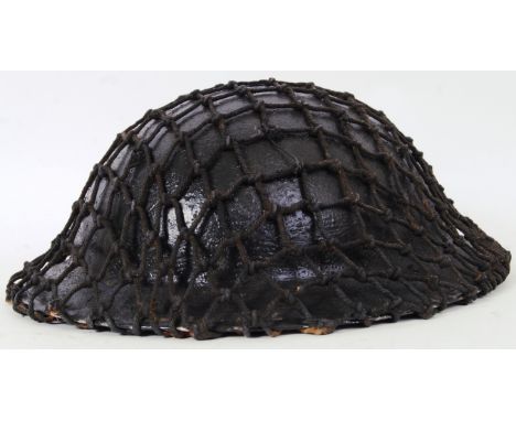 An original WWII Second World War British uniform helmet, complete with webbing and original liner.  POSTAGE: Worldwide posta