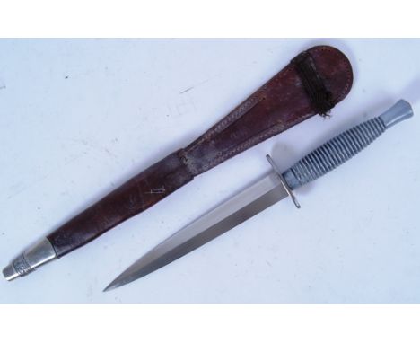 A Fairburn &amp; Sykes style hunting / combat dagger knife. With white metal and leather scabbard. 30cm long