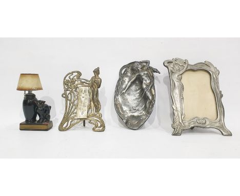 Art Nouveau style metalware including photograph frame, a pottery lighter in the form of a cat seated by a lamp