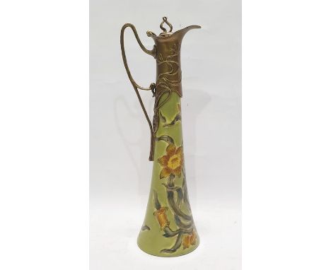 Art Nouveau style ceramic and gilt metal-mounted claret jug, the tall flared body decorated with scrolling daffodils and moun