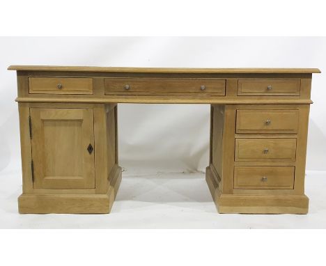 Modern oak desk, the rectangular top with moulded edge, assorted drawers and cupboard doors, the whole raised on plinth base,