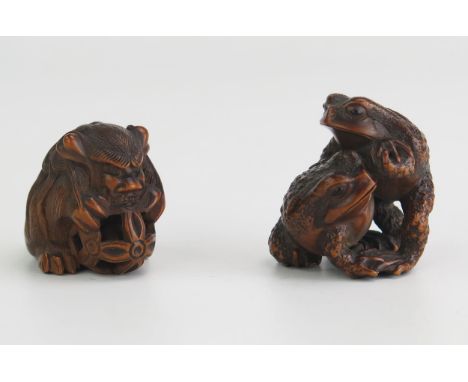 A Japanese carved hardwood netsuke of two toads, signed, 3.5cm high, together with another boxwood netsuke of a temple dog ho