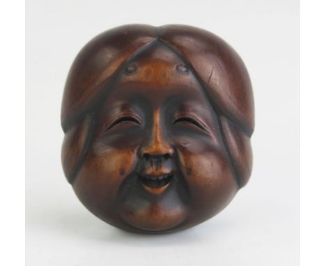 A Japanese carved boxwood netsuke of a female noh theatre mask, signed possibly Gyokushu, to the ivory tablet, 4cm wide, Meij