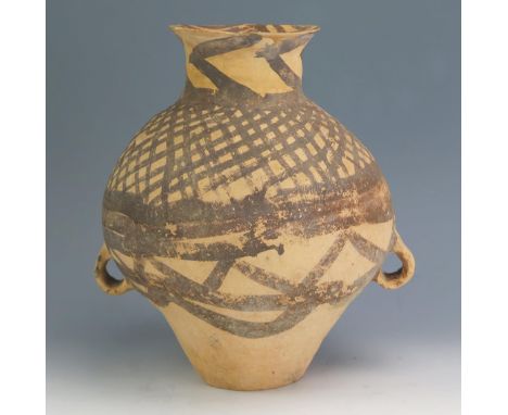 A Chinese Neolithic terracotta jar, of ovoid form, with painted geometric decoration, with loop handles to the sides, 31cm wi