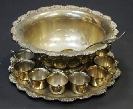 An Italian silver plated punch bowl, stand, ladle and twelve punch cups, the rim applied with fruiting vine, 42.5cm diam