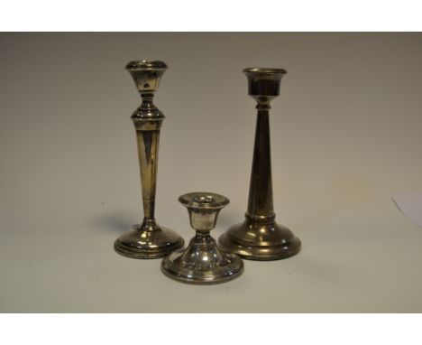 A silver candlestick, Birmingham 1922; another rubbed marks; a boudoir candlestick, Birmingham, 1910 (3)