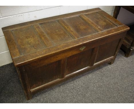 An 18th century oak blanket box, four panel hinged cover, three panels to front, stile feet, 60cm high, 128cm long, c.1740 