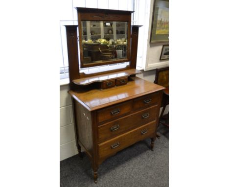 An Art Nouveau oak dressing chest, rectangular mirror, shaped mirror and two small drawers to superstructure, two short drawe