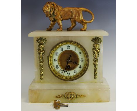 A 19th century Alabaster clock garniture, the 11cm Arabic numerals, the architectural case surmounted with a gilt lion, 31cm 