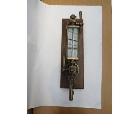 An industrial steam engine water gauge on mount with glass protector   