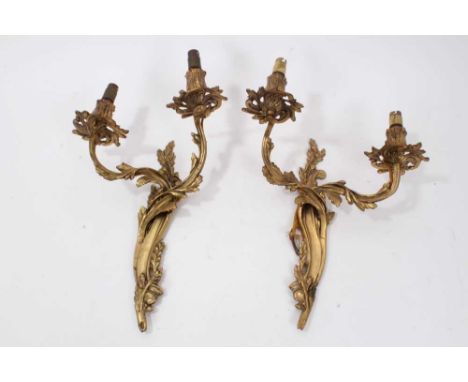 Pair of Rococo style gilt metal wall sconces, each scrolling foliate bracket issuing twin arms, 31cm high