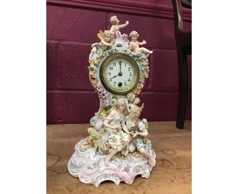 Decorative china mantel clock with courting couple and cherubs and enamelled dial