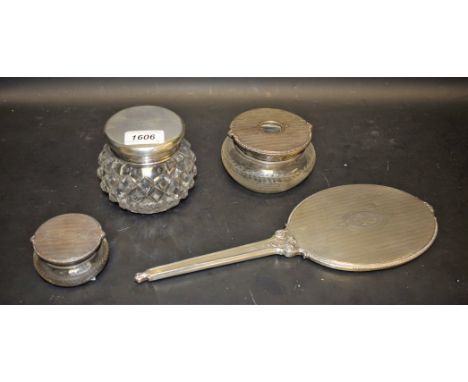 Three silver topped dressing table jars; a silver hand mirror (4)