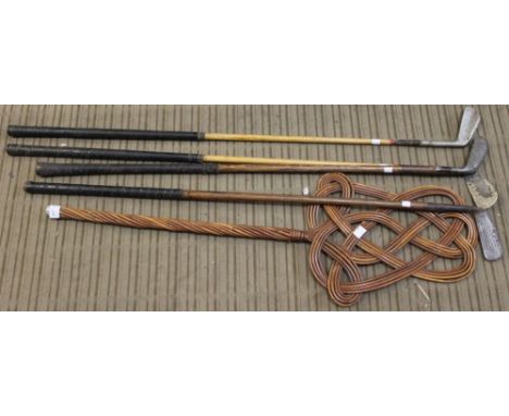 Four hickory shafted golf clubs and a carpet beater