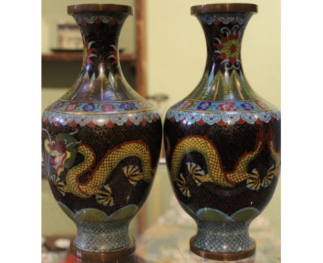 A pair of Chinese cloisonné vases, ebonised bodies with dragons chasing the fiery pearl 23cm high (2)  Condition: Condition g