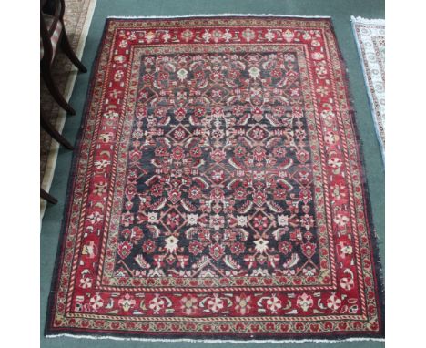 A Persian design rug, with noire ground having crimson stylised floral decoration, multi-bordered, 210cm x 159cm