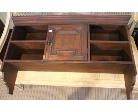 A dark pine hanging shelf with cupboard
