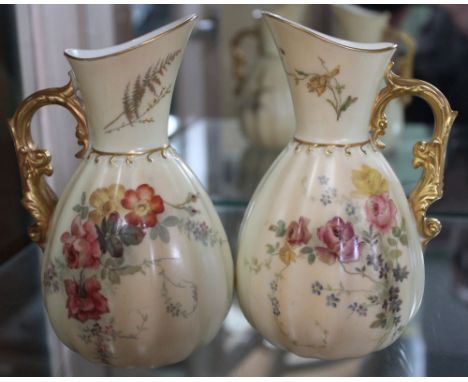 A pair of Royal Worcester porcelain jugs, floral painted with gilded handles, factory marks and number 1436 to base, 14cm hig