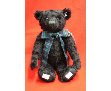 A Steiff musical black mohair bear, with tartan bow and pads, having white limited edition label, plays a Scottish jig, 28cm&