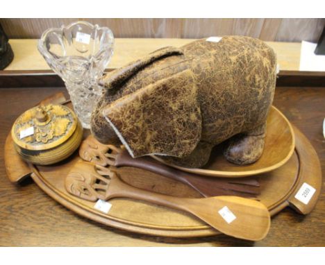 A selection of carved wooden artefacts to include trays and salad spoons together with an elephant door stop