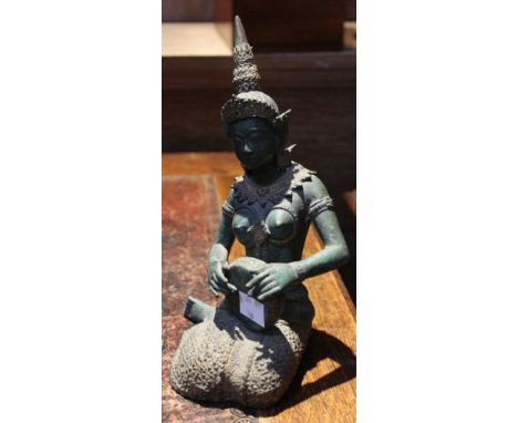 A Far Eastern Temple Dancer figure, seated with tambourine, cast metal, green patination and parcel gilt, 21cm