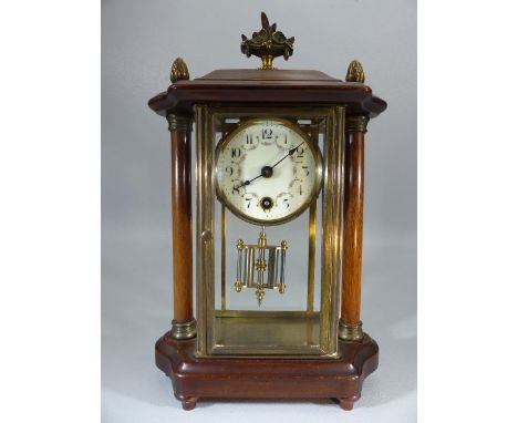 Mantle clock in brass and bevelled glass case and with wooden outer case with two columns and finials and a floral decorated 