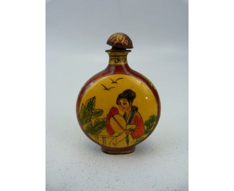Unusual oriental snuff bottle of enamel over metal. The circular bodied bottle with two enamelled panels depicting oriental l