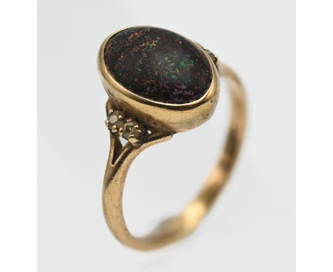 A 9ct gold and black opal set ring, embellished with four further diamonds on the shoulders, approx 4.85g.