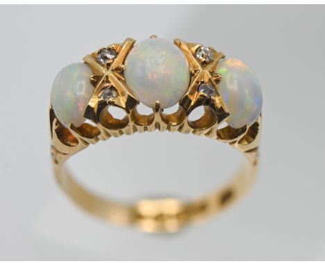 An 18ct gold three stone opal and diamond ring, size K/L.