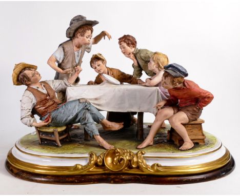 A large Capodimonte group of 6 children sitting around a table watching a magic trick, length 50cm (a/f - hairline to rear of