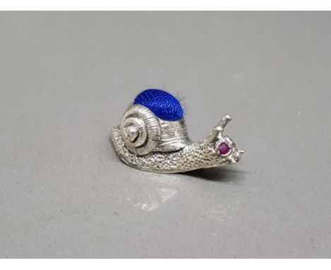 A silver pincushion in the form of a snail set with ruby eyes 5.58g gross