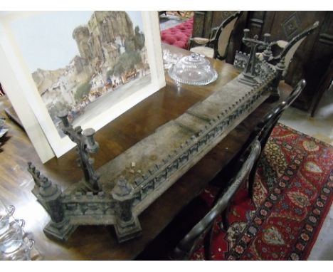 A 19th Century Gothic Style Cast Iron Fender, with castle shaped front, fixed fire irons.