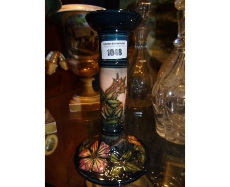 A Moorcroft Pottery Candlestick in the Sweet Briar pattern tube lined in pinks, green, brown on a graduating blue pink ground