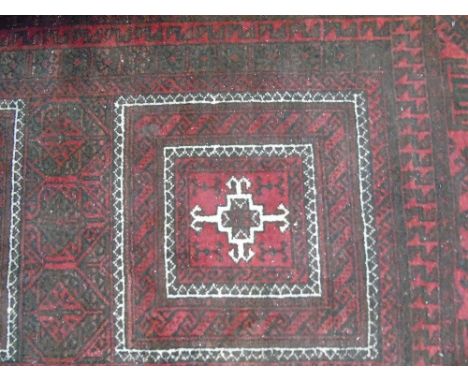 A Persian Style Red Wool Carpet with geometric detail upon a red ground, within further running borders, 200 x 105 cm