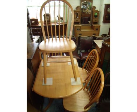 Light wood drop-leaf kitchen table and a set of four stick back dining chairs 