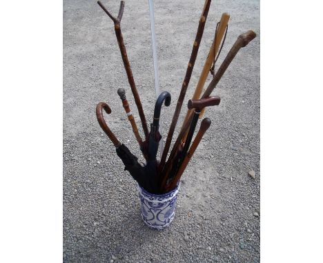 Blue &amp; white ceramic stick stand containing a selection of various walking sticks, umbrellas, thumb sticks etc some with 