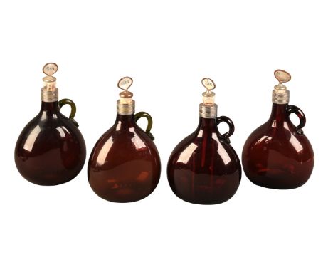 A SET OF FOUR EARLY VICTORIAN AMBER GLASS SPIRIT FLASKS the bulbous pear-shaped bodies with single loop handles and plated ne