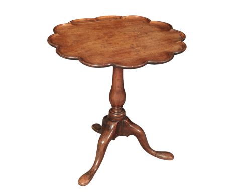 A GEORGE II MAHOGANY TRIPOD TABLEthe scalloped tilt top on a baluster turned stem terminating in cabriole legs and pad feet, 