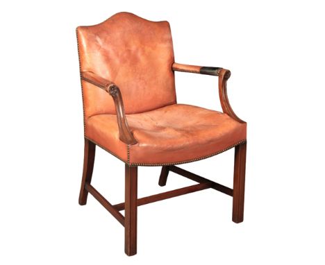 A GEORGE III STYLE MAHOGANY ARMCHAIR with worn studded leather covers, on moulded square legs joined by stretchers, 93cm high