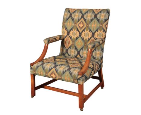 A GEORGE III WALNUT GAINSBOROUGH ARMCHAIRwith blue Aztec pattern covers, the square back over a square seat, on block front l